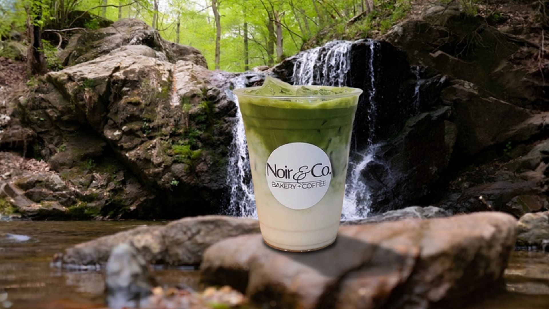 Iced matcha latte from Noir Bakery & Coffee Co. beside a waterfall near North East, Maryland